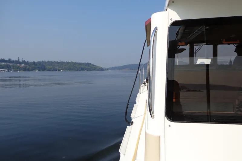 Slide: The Image of 2016 Ranger Tugs R-31 S cruising on a calm lake with scenic shoreline views. - 66