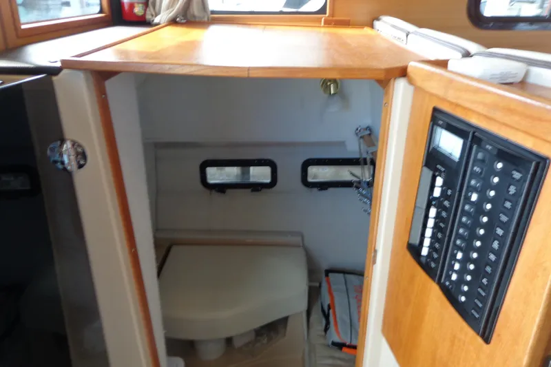 Slide: The Image of 2016 Ranger Tugs R-31 S interior cabin with control panel and compact bathroom. - 31