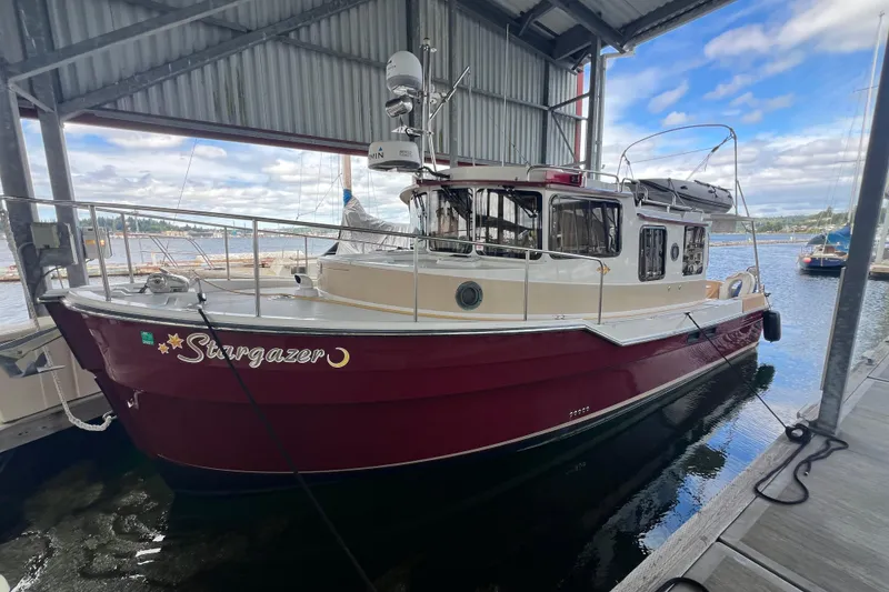Slide: The Image of 2016 Ranger Tugs R-31 S "Stargazer" docked under a covered marina with scenic water views. - 2
