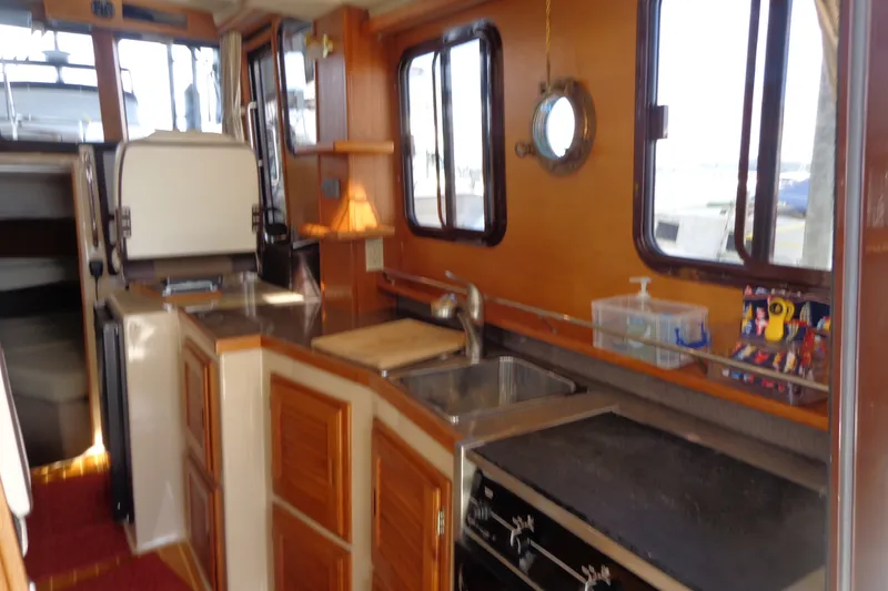 Slide: The Image of 2016 Ranger Tugs R-31 S interior kitchen with wooden cabinetry and stainless steel sink. - 35