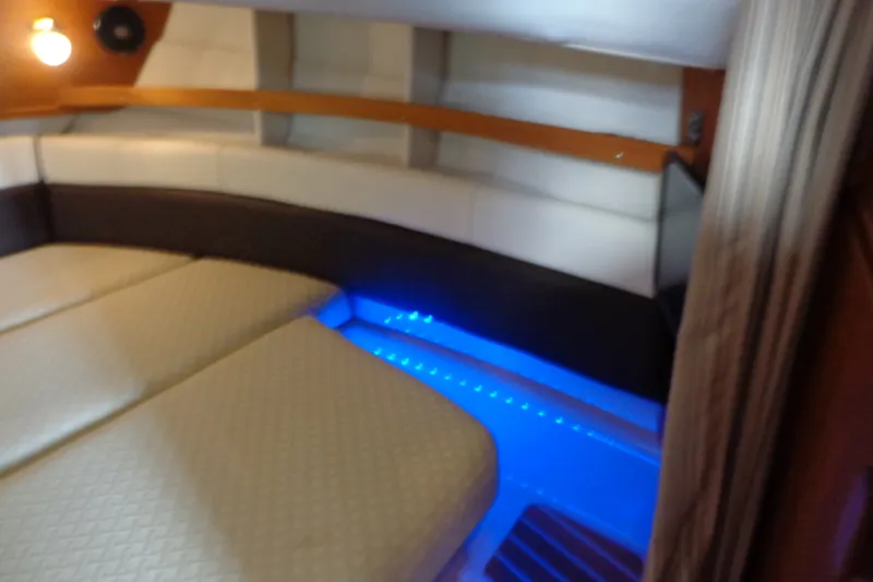 Slide: The Image of 2016 Ranger Tugs R-31 S interior cabin with cozy seating and ambient blue lighting. - 24