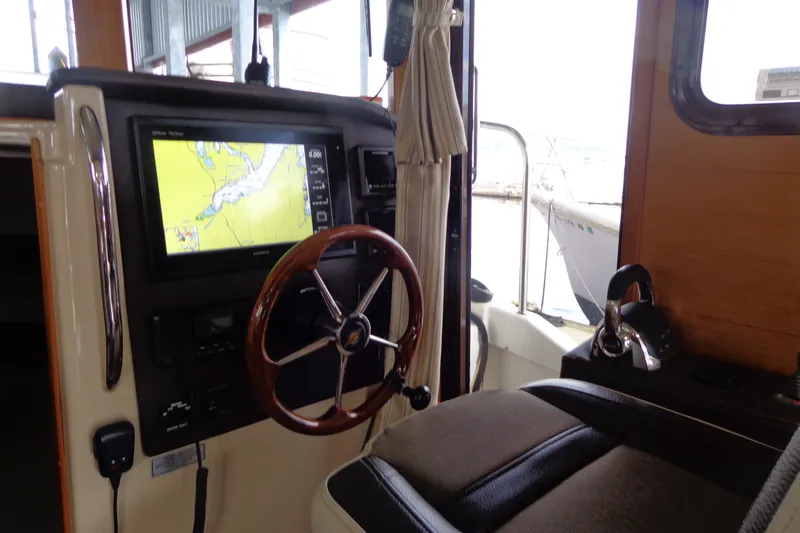 Slide: The Image of 2016 Ranger Tugs R-31 S helm with navigation display and steering wheel. - 20