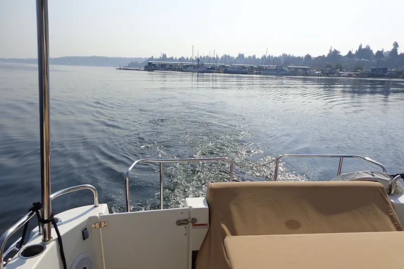 Slide: The Image of 2016 Ranger Tugs R-31 S cruising on calm waters near a marina. - 67