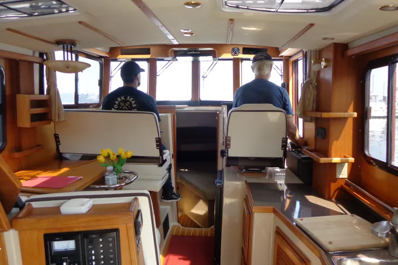 Slide: The Image of Interior of 2016 Ranger Tugs R-31 S boat with two people at helm. - 79