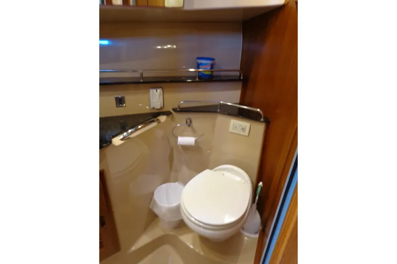 Slide: The Image of 2016 Ranger Tugs R-31 S boat bathroom with toilet, countertop, and storage shelf. - 28