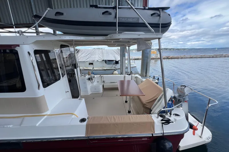 Slide: The Image of 2016 Ranger Tugs R-31 S boat docked, featuring spacious deck and mounted dinghy. - 3