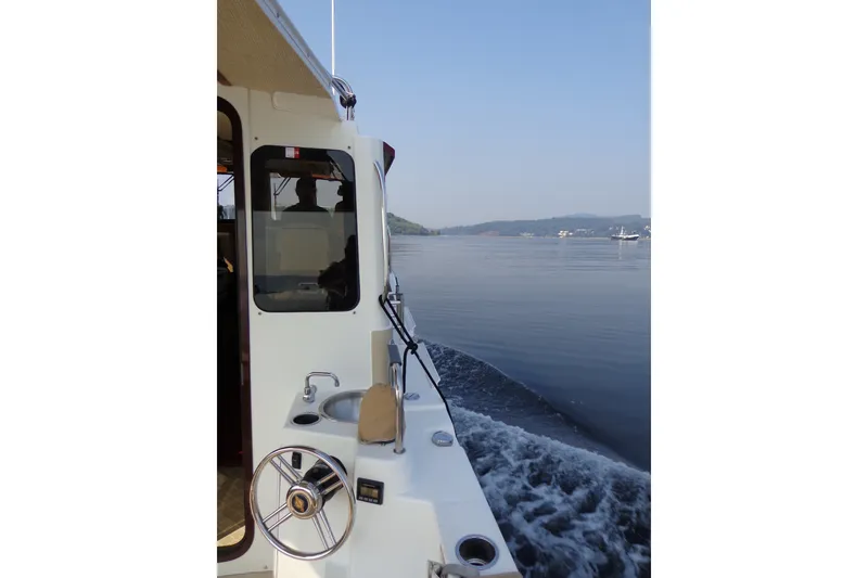 Slide: The Image of 2016 Ranger Tugs R-31 S cruising on calm waters, scenic view in background. - 68