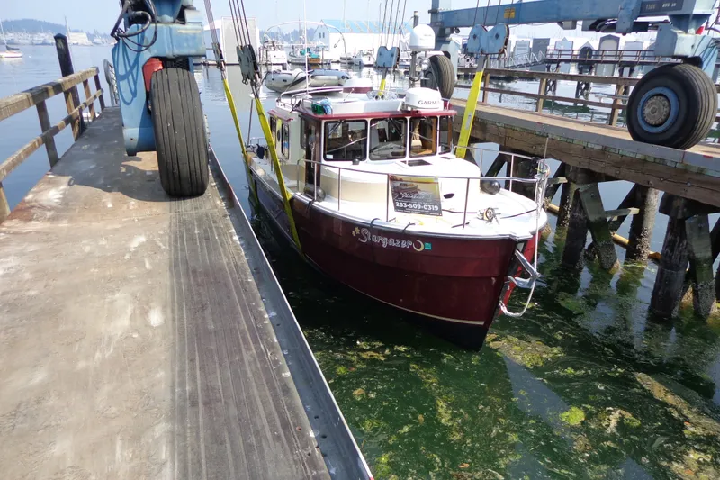 Slide: The Image of 2016 Ranger Tugs R-31 S boat docked at a marina with lifting equipment. - 74