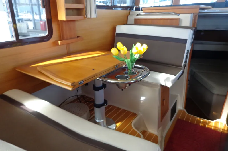 Slide: The Image of Interior of 2016 Ranger Tugs R-31 S with table and yellow tulips. - 37