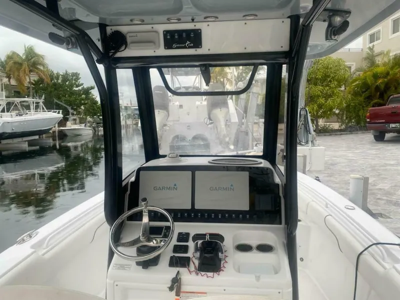 Slide: The Image of The cockpit of a 2018 Sea Hunt Gamefish 27 with Garmin electronics and steering controls. - 7