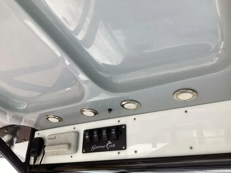 Slide: The Image of The image shows the helm of a Sea Hunt Gamefish 27 boat with switches and lighting. - 38