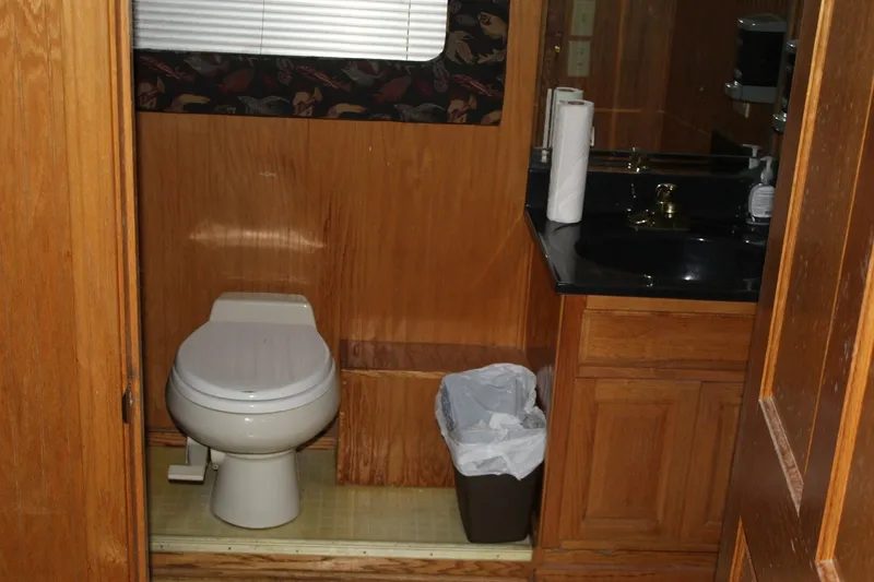 Slide: The Image of The image shows a bathroom with wooden walls, a toilet, and a sink with a black countertop. - 26