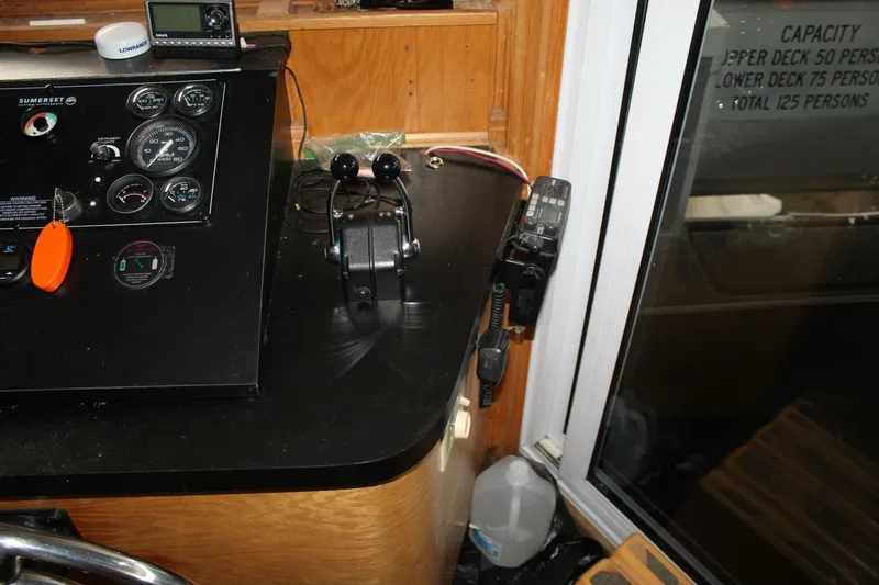 Slide: The Image of The image shows the helm of a 2000 Sumerset 75 Houston with instruments and throttle controls. - 34