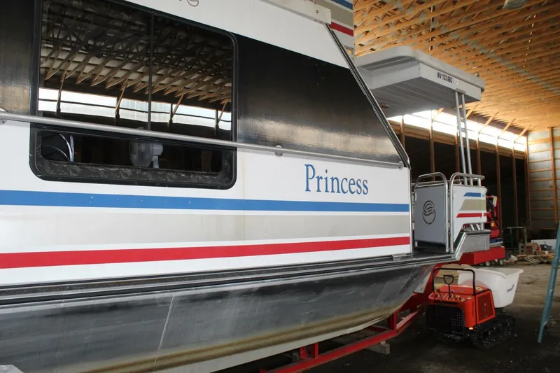 Slide: The Image of A 2000 Sumerset 75 Houston houseboat in a storage facility. It is named "Princess." - 10