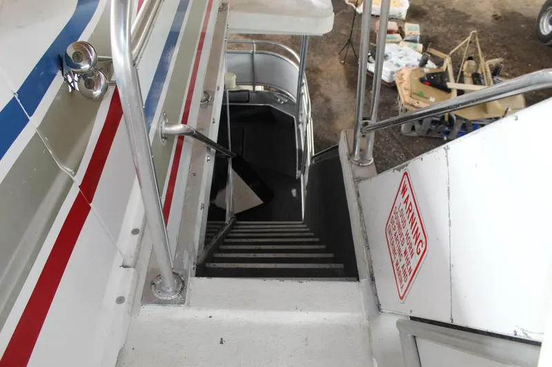 Slide: The Image of A staircase descends from the deck of a Sumerset 75 Houston houseboat. Metal railings are visible. - 30