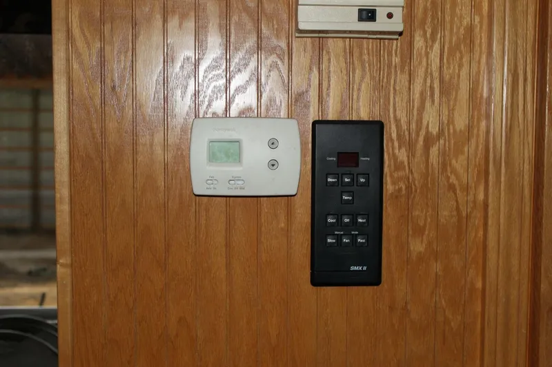 Slide: The Image of A wooden panel with a thermostat and a control panel. - 28