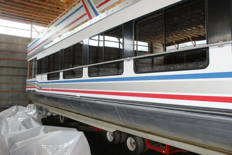 Slide: The Image of A 2000 Sumerset 75 Houston houseboat is stored on a trailer in a warehouse. - 3