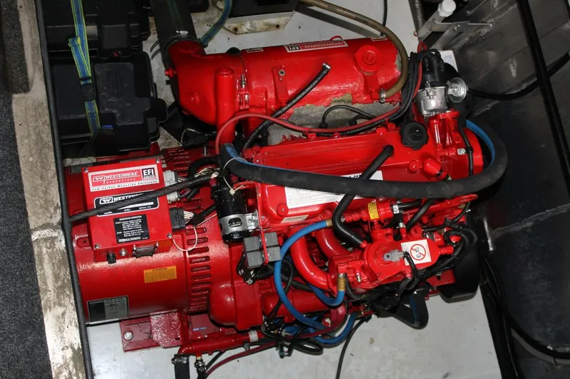 Slide: The Image of A red engine in a boat's engine compartment, surrounded by cables and hoses. - 18