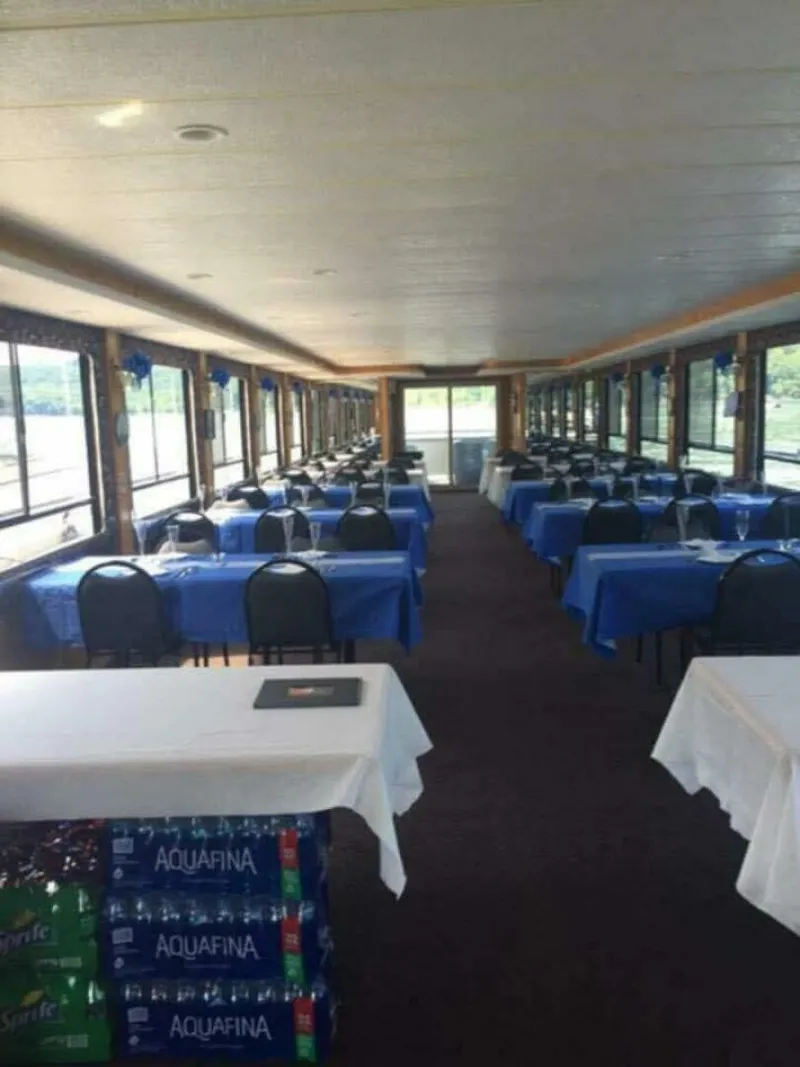 Slide: The Image of The interior of a 2000 Sumerset 75 Houston features a large dining area with tables covered in blue. - 14