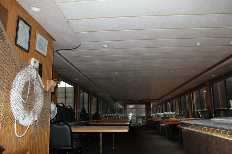 Slide: The Image of The interior of a 2000 Sumerset 75 Houston with tables, chairs, and a life ring on the wall. - 32