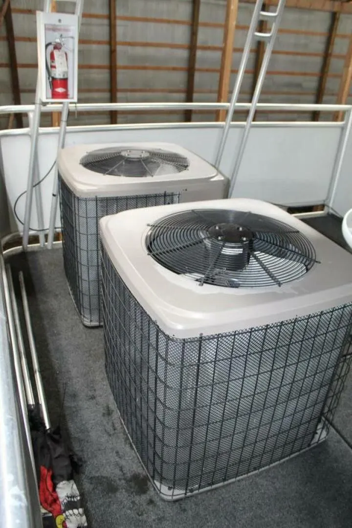 Slide: The Image of Two large air conditioning units on a boat deck, surrounded by metal railings. - 21