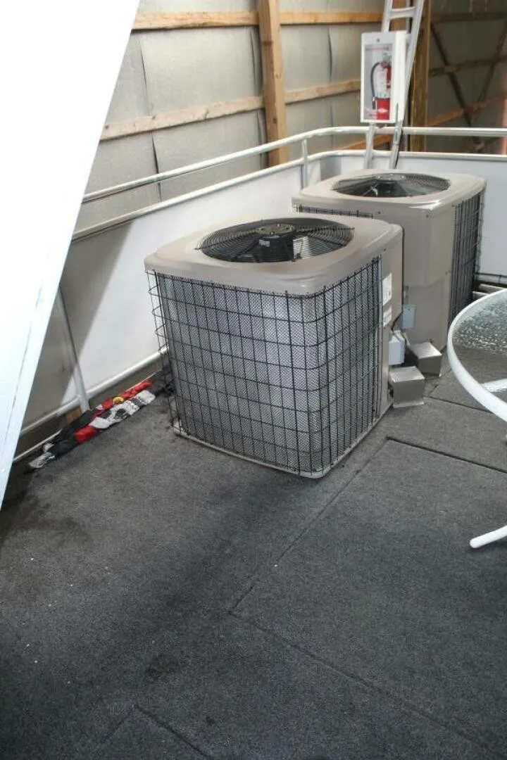 Slide: The Image of Two air conditioning units on a carpeted floor, surrounded by metal railings, in a covered area. - 24