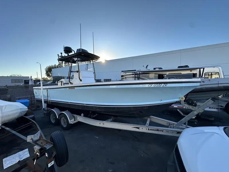 The Image of A 2006 Albin 26 Center Console boat on a trailer, surrounded by other vehicles. - 0