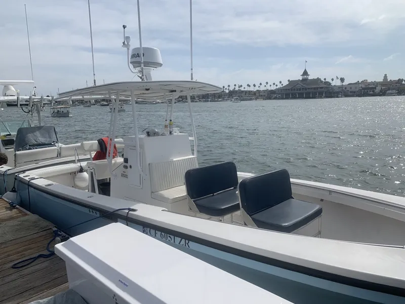 Slide: The Image of A 2006 Albin 26 Center Console boat docked. It features an open cabin and seating area. - 19