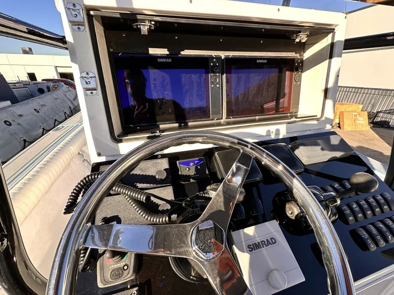 Slide: The Image of The image shows the helm of a 2006 Albin 26 Center Console boat with Simrad electronics. - 10