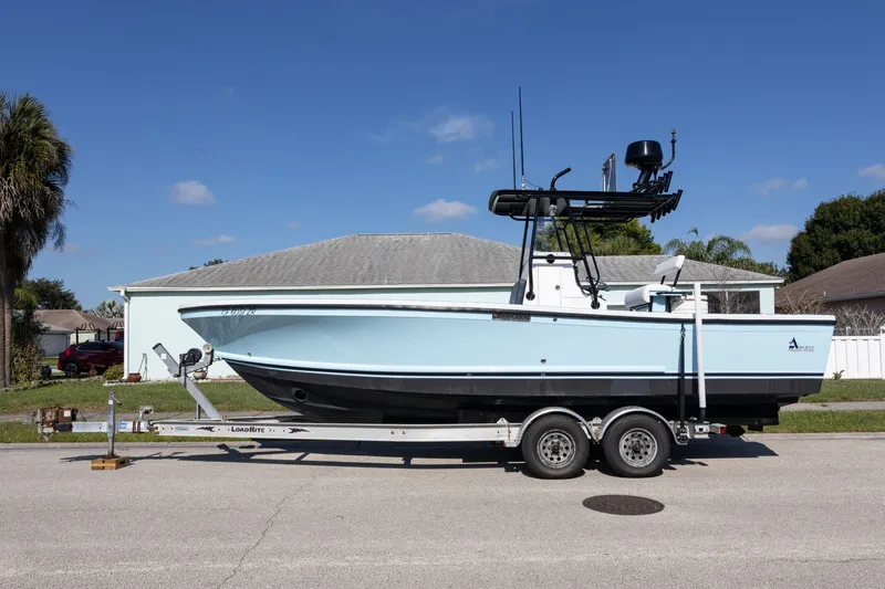 The Image of A 2006 Albin 26 Center Console boat on a trailer, parked in front of a house. - 0