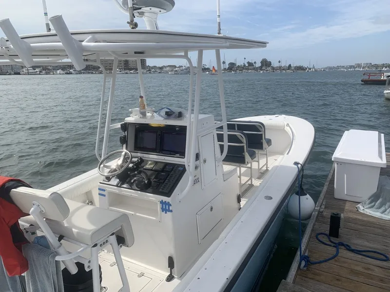 Slide: The Image of A 2006 Albin 26 Center Console boat docked. It features a modern helm station. - 2