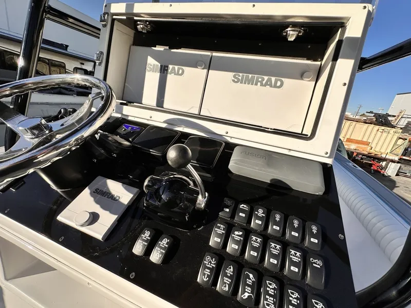 Slide: The Image of The image shows the helm of a 2006 Albin 26 Center Console boat with Simrad electronics. - 7