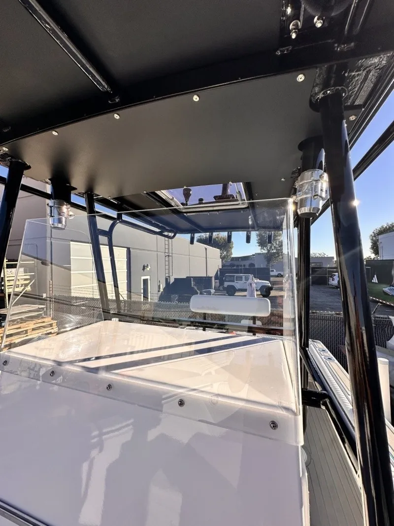 Slide: The Image of The image shows the cockpit of a 2006 Albin 26 Center Console boat with a black roof. - 13