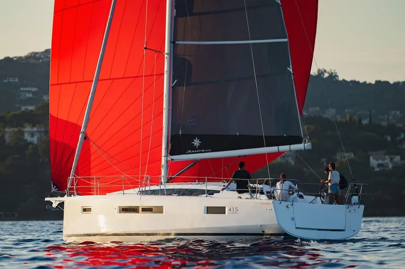 The Image of Manufacturer Provided Image: 2025 Jeanneau Sun Odyssey 415 sailing with vibrant red sails on calm waters. - 0