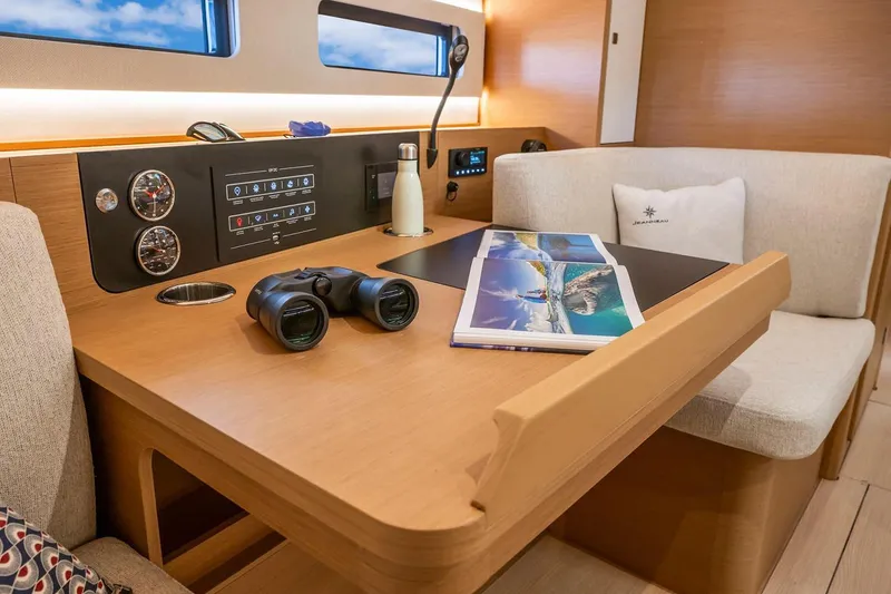 Slide: The Image of Manufacturer Provided Image: 2025 Jeanneau Sun Odyssey 415 interior with navigation station, binoculars, and brochure. - 4