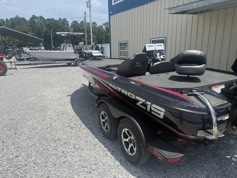 Slide: The Image of A black Nitro Z19 boat sits on a trailer in a gravel lot. - 5