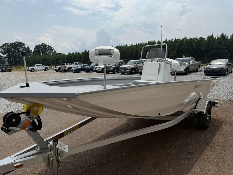 Slide: The Image of A white G3 Bay 17 boat on a trailer, surrounded by cars and trees in the background. - 3