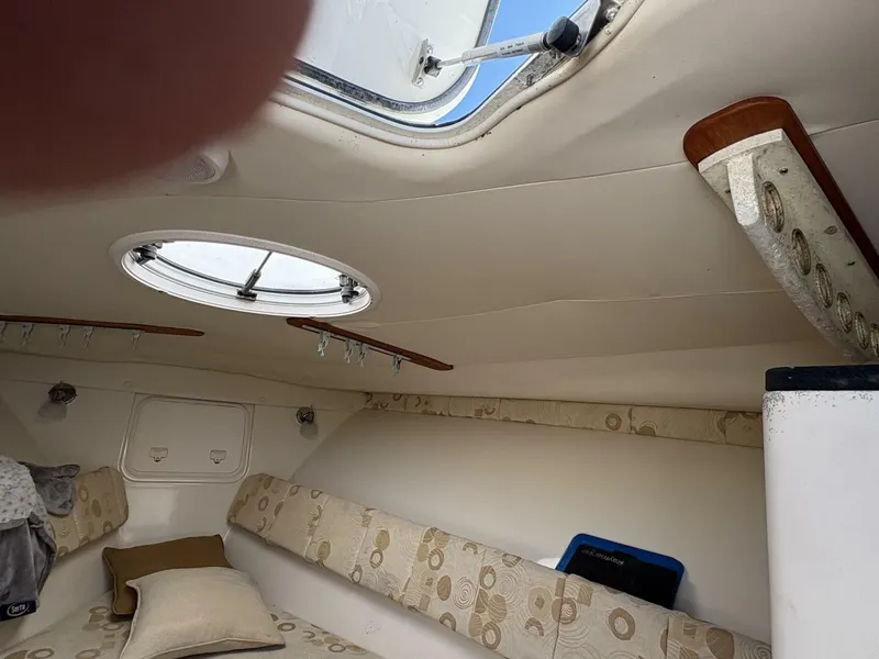 Slide: The Image of Interior view of a cabin with cushions and a porthole, in a 2008 Wellcraft 35 Scarab Sport. - 16