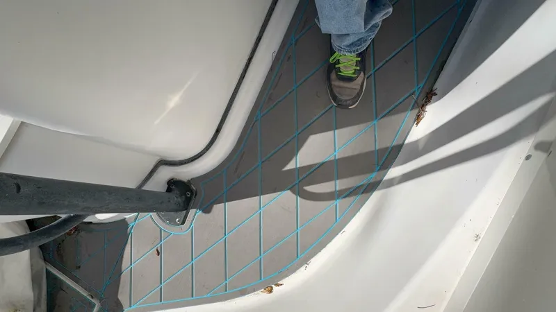 Slide: The Image of A section of the boat deck with blue diamond lines and a foot in a shoe visible. - 42