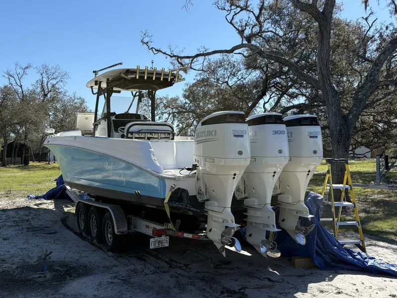 The Image of A 2008 Wellcraft 35 Scarab Sport on a trailer. Three Suzuki engines are visible. - 0