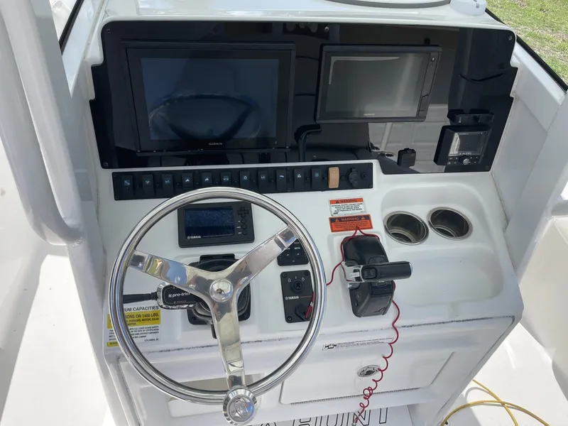 Slide: The Image of The image shows the helm of a 2020 Sea Hunt BX 25 FS boat with modern instruments. - 23
