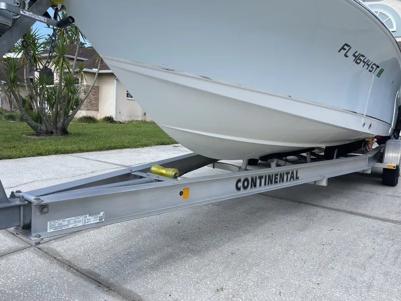 Slide: The Image of A 2020 Sea Hunt BX 25 FS boat on a Continental trailer, parked on a driveway. - 17
