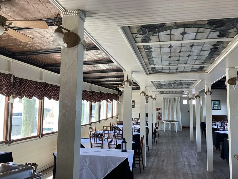 Slide: The Image of An elegant dining area on a boat with wooden floors, decorative ceilings, and set tables. - 22