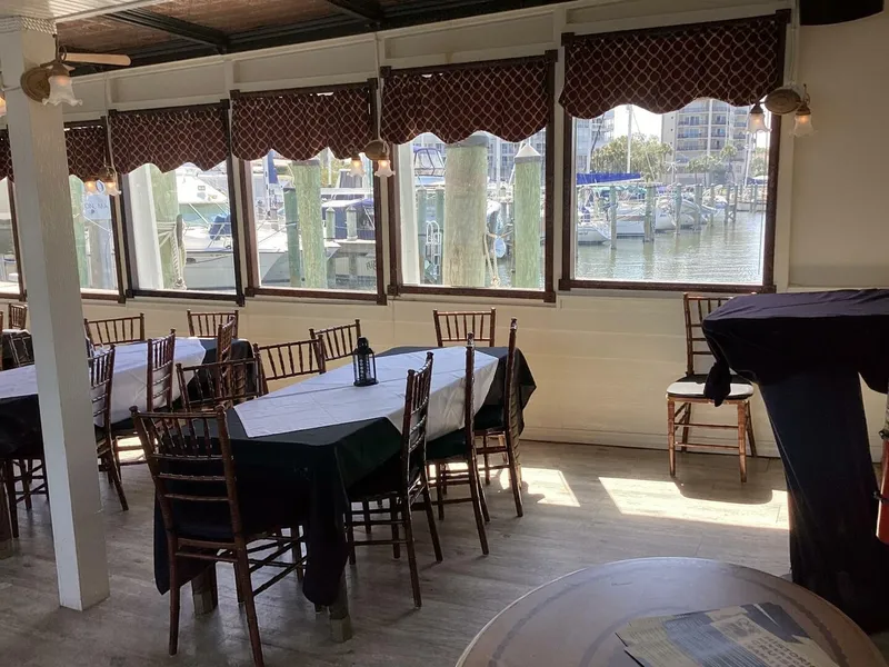 Slide: The Image of A cozy interior with set tables and a view of a marina through large windows. - 44