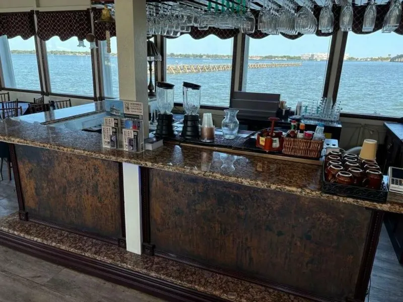 Slide: The Image of A bar with a marble countertop on a boat overlooking the water. - 29