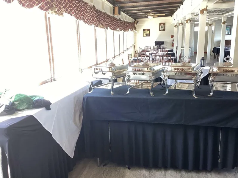 Slide: The Image of A buffet setup with chafing dishes in a room with chairs and decorative curtains. - 30