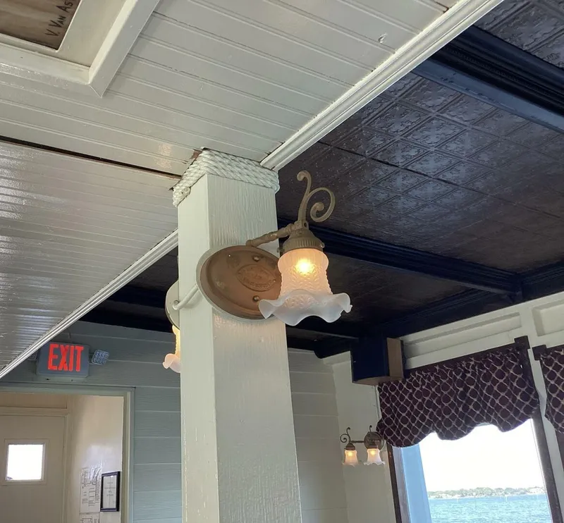 Slide: The Image of A decorative light on a boat with wooden walls and a window with a curtain. - 39