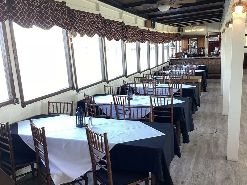 Slide: The Image of An elegant dining area with set tables and wooden chairs on a boat. - 42
