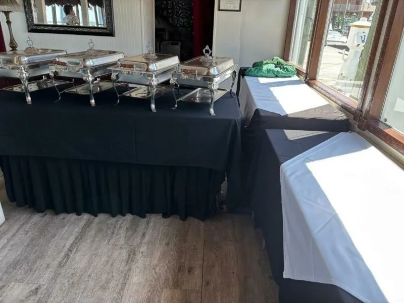 Slide: The Image of A buffet setup with several chafing dishes on a table with a black tablecloth. - 45