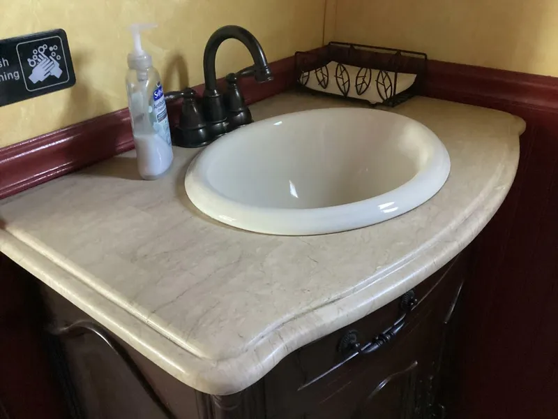 Slide: The Image of An elegant sink with a marble-like countertop and a dark faucet. - 46
